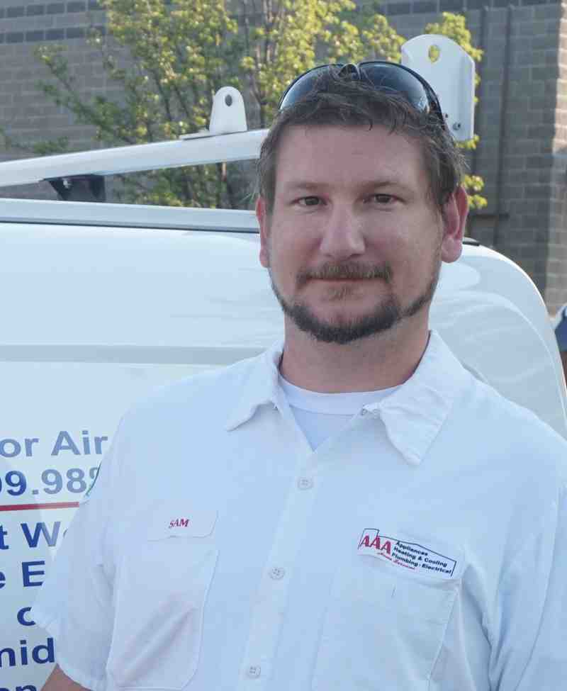 A friendly AAA technician smiling next to a service van - same day water heater A friendly AAA technician smiling next to a service van - same day water heater